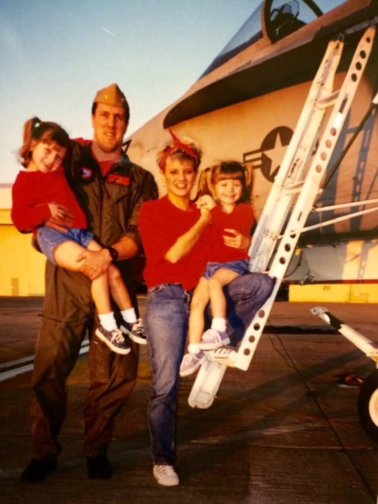 military family posing in front of jet