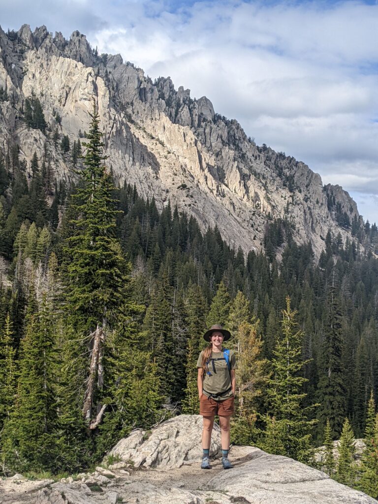 girl standing by tall mountains