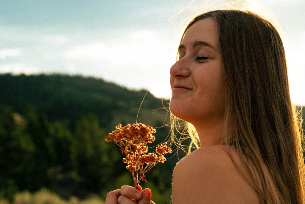 headshot of woman sniffing flowers