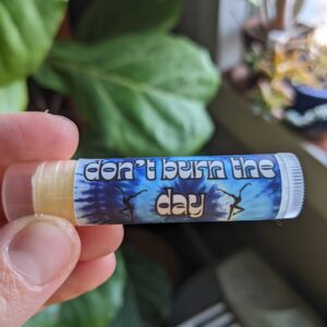 blue tie dye chapstick tube with plants in the background