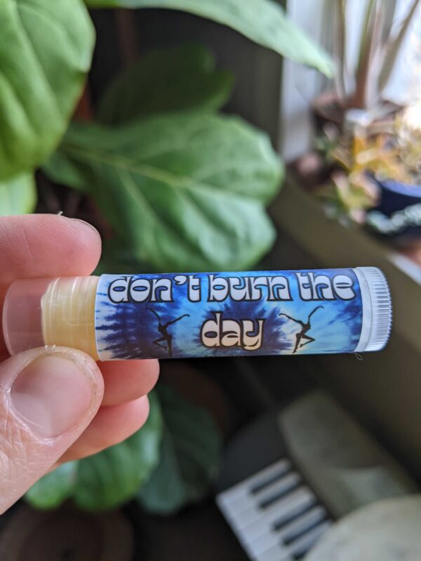 blue tie dye chapstick tube with plants in the background